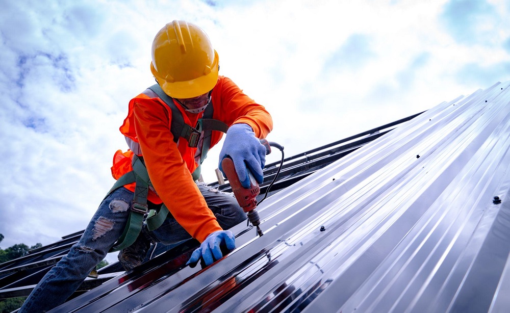 worker screwing new metal roof